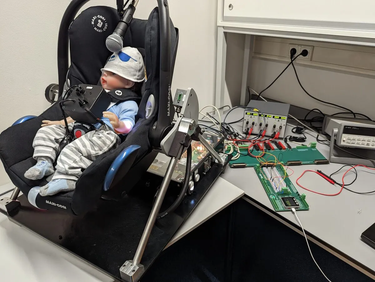 The baby simulator in the rocking cradle with the microphone, motor and M5Stack modules wired up